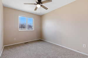Spare room featuring a ceiling fan and carpet flooring