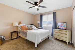 Primary bedroom with carpet, ceiling fan, and a closet