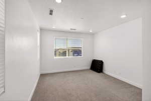 Empty room with light colored carpet and baseboards