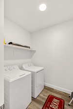Laundry area with light wood-style floors and washer and dryer