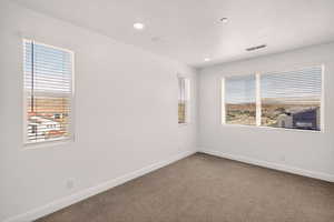 Carpeted spare room with baseboards and recessed lighting