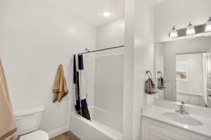 Bathroom with vanity, shower / bath combination with curtain, and light wood-style flooring