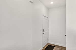 Doorway to outside featuring wood finished floors and baseboards