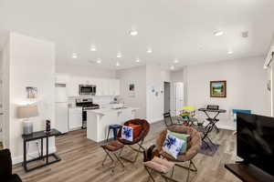 Living area with light wood-style flooring and recessed lighting