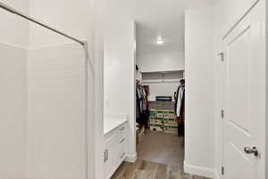 Walk in closet with light wood-style flooring