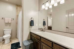 Full bath with vanity, a shower with shower curtain, and light tile patterned flooring