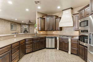 Kitchen with dark wood finish cabinetry, ceiling fan, stainless steel appliances, and recessed lighting