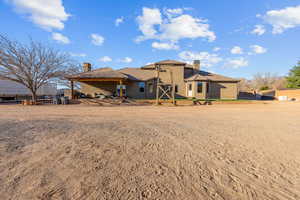 Back of property with a chimney, a patio area, and stucco siding
