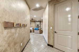 Corridor featuring stone tile floors, recessed lighting, and a textured wall