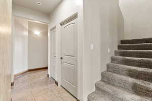 Staircase with stone tile flooring and baseboards