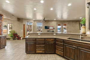 Kitchen featuring dark wood finish cabinetry, plenty of natural light, a ceiling fan, and recessed lighting