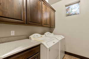 Laundry area featuring washer and dryer and cabinet space