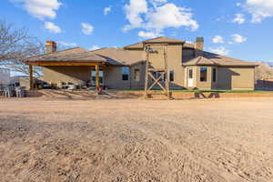 Rear view of house featuring a chimney, stucco siding, a patio area, and a tile roof