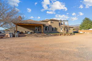 Rear view of house with a patio area, stucco siding, a chimney, a tiled roof, and a mountain view
