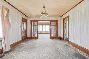 Unfurnished sunroom featuring a chandelier and french doors