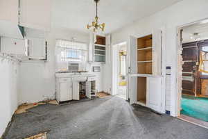 Kitchen with a textured ceiling, suspended lighting, and cooling unit
