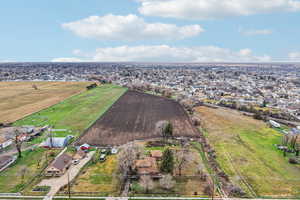 Overview of rural landscape with rows of crops and nearby suburban area