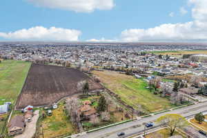 View of rural area featuring farmland and nearby suburban area