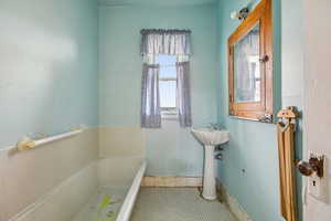 Full bathroom featuring a bath and a sink