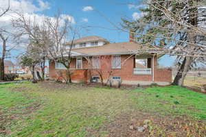 View of front of property with brick siding, roof with shingles, and a chimney