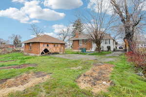 Back of property featuring brick siding and a chimney