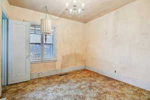 Unfurnished dining area featuring hanging lights and baseboards