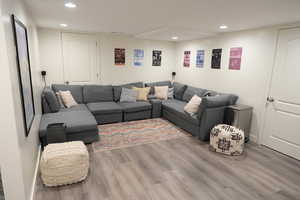 Living room with light wood-type flooring and recessed lighting