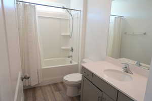 Full bath with vanity, dark wood-type flooring, and shower / bath combination with curtain