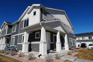 View of side of home with covered porch and stone siding
