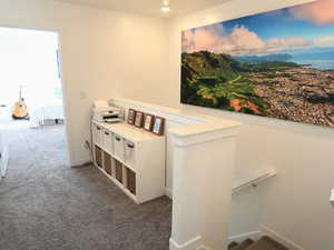 Hall featuring dark colored carpet, recessed lighting, and an upstairs landing