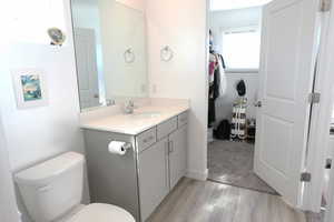 Bathroom with vanity, light wood-style flooring, and light colored carpet
