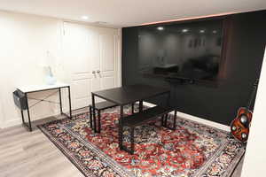 Living area with light wood finished floors and recessed lighting