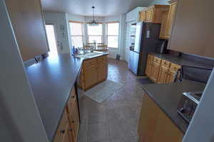 Kitchen featuring dark countertops, stainless steel appliances, a chandelier, a textured ceiling, and a peninsula