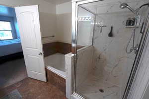 Full bathroom with a marble finish shower, a bath, connected bathroom, and dark tile patterned floors
