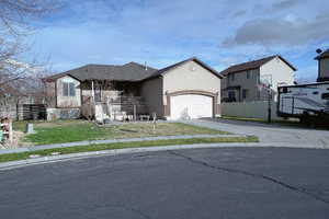 View of front of property with a garage, driveway, and stucco siding
