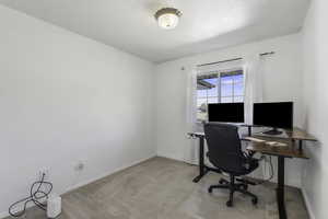 Office featuring light colored carpet and baseboards