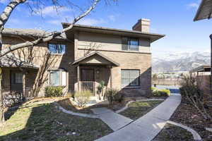 View of front of house featuring a chimney, brick siding, and a mountain view