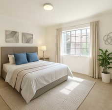 Bedroom with light colored carpet and crown molding