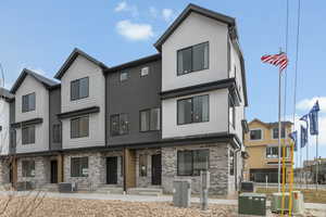 View of front of house with stucco siding, brick siding, a patio, and entry steps