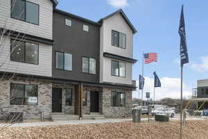Rear view of property with brick siding, stucco siding, and entry steps