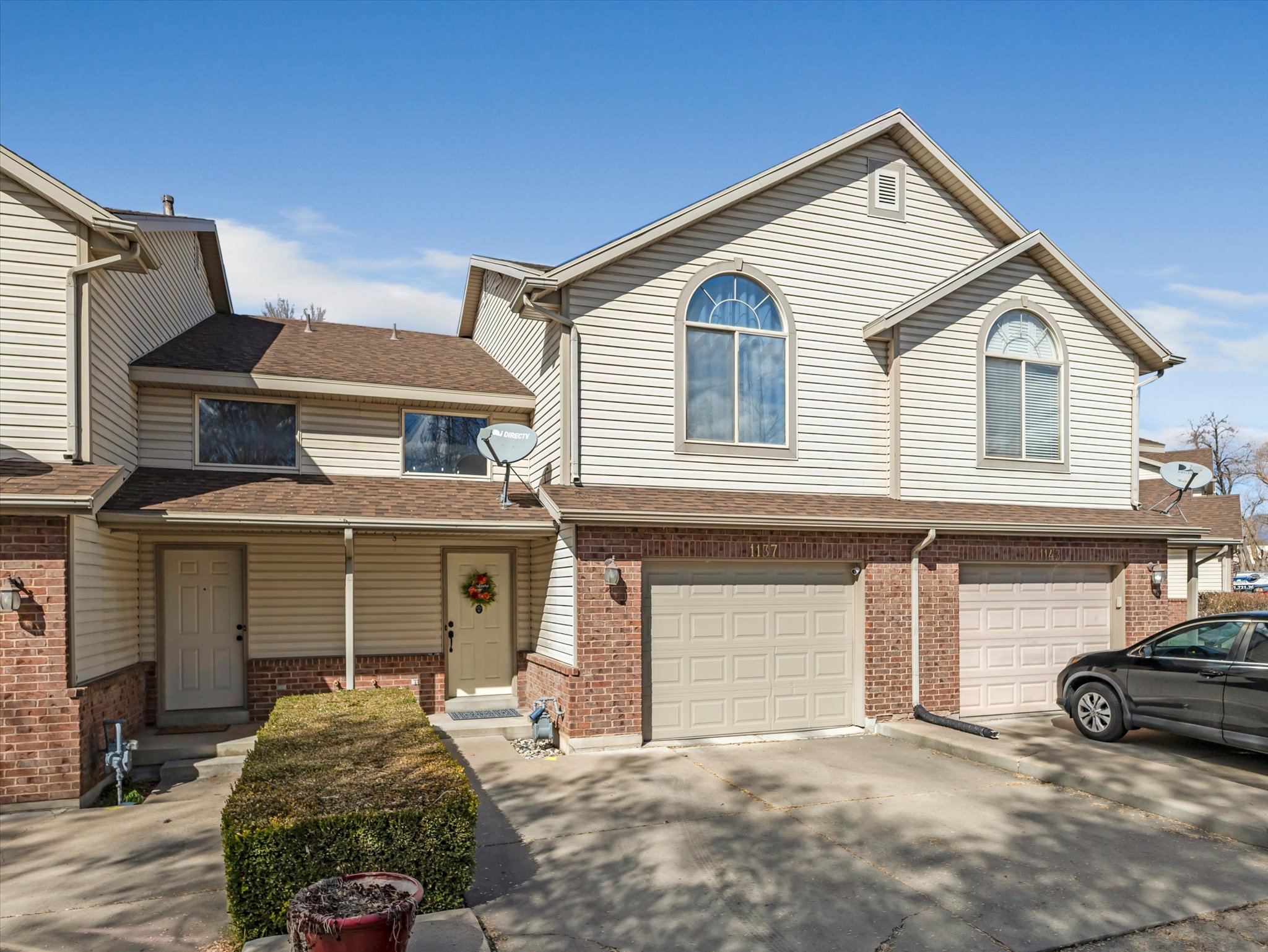 Traditional-style home with a shingled roof, driveway, a garage, and brick siding