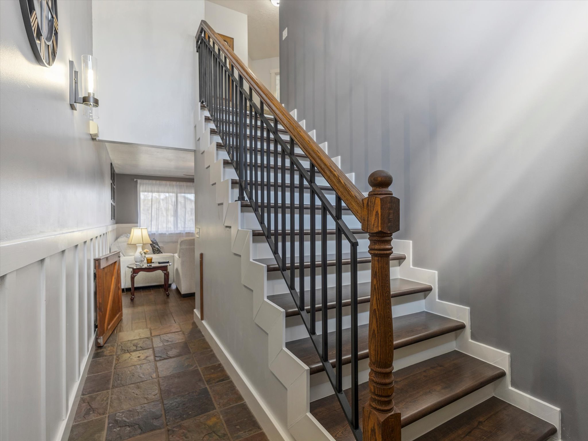 Stairway with stone tile floors and baseboards