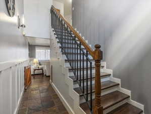 Stairway with stone tile floors and baseboards