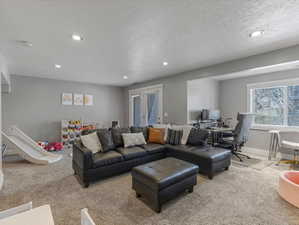 Living area featuring a textured ceiling, recessed lighting, carpet floors, and an office area