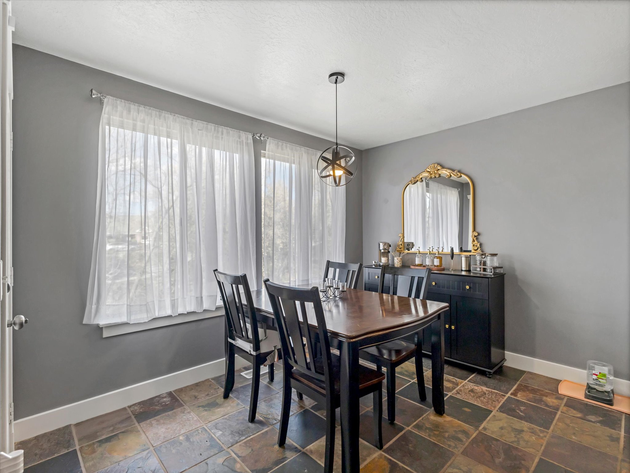 Dining area with baseboards and stone tile floors
