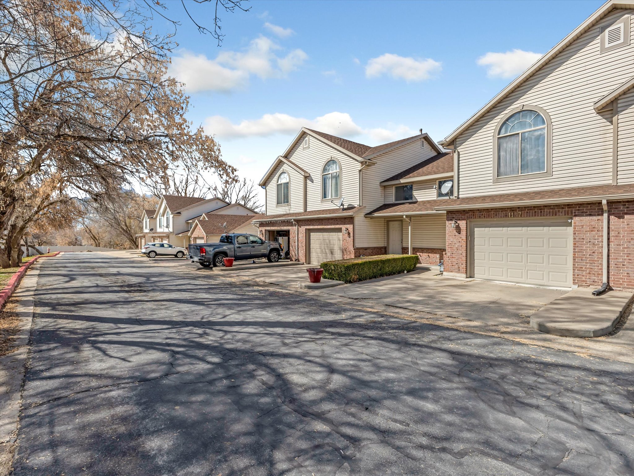 View of front of house with brick siding, driveway, a residential view, and a garage