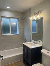 Full bath featuring vanity, bathing tub / shower combination, and light wood-style flooring
