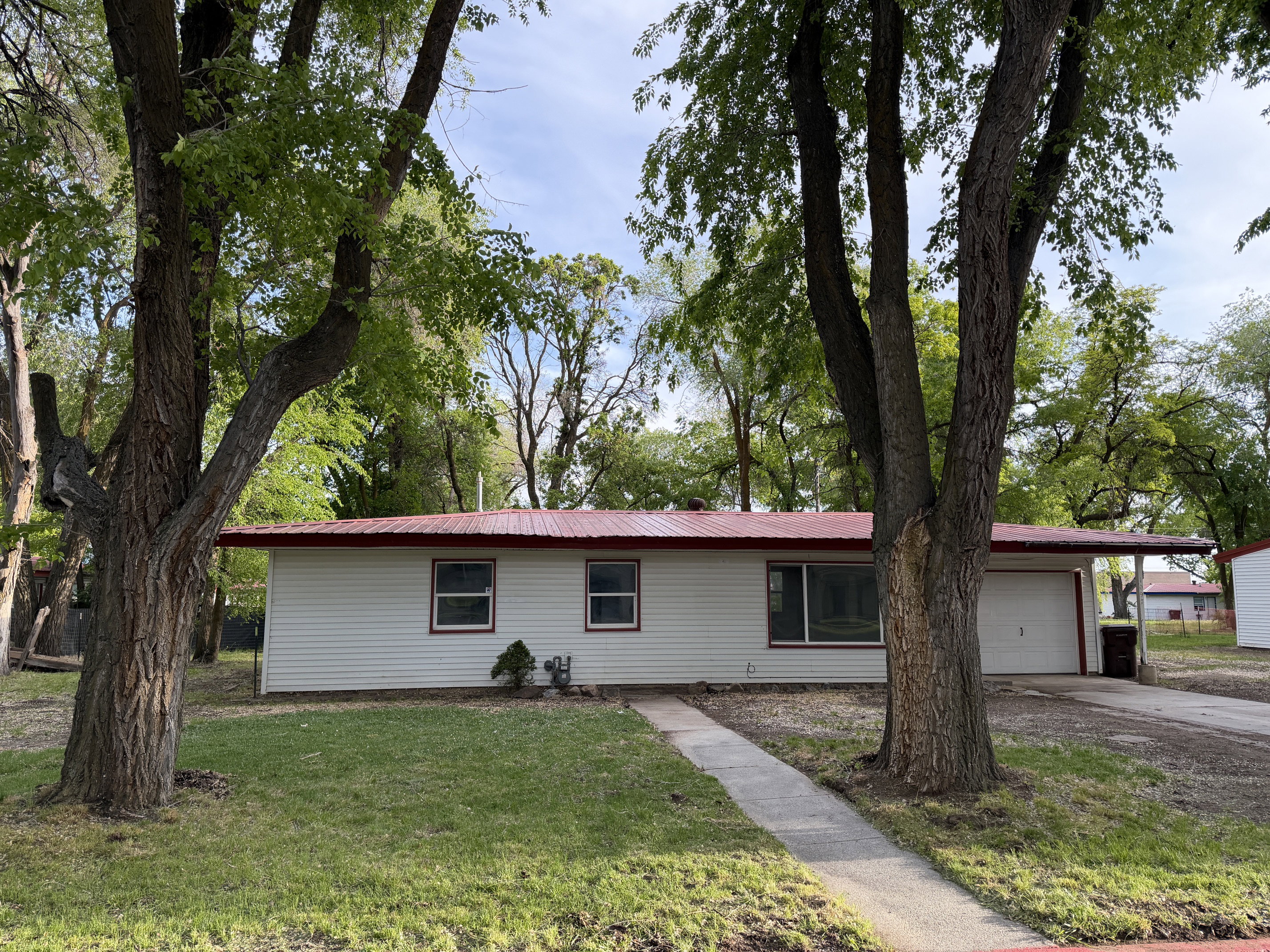 Single story home with a garage, concrete driveway, and a front yard