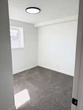 Spare room featuring carpet floors and a textured ceiling