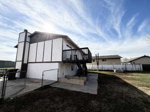 Rear view of house featuring a fenced backyard, a gate, and a patio